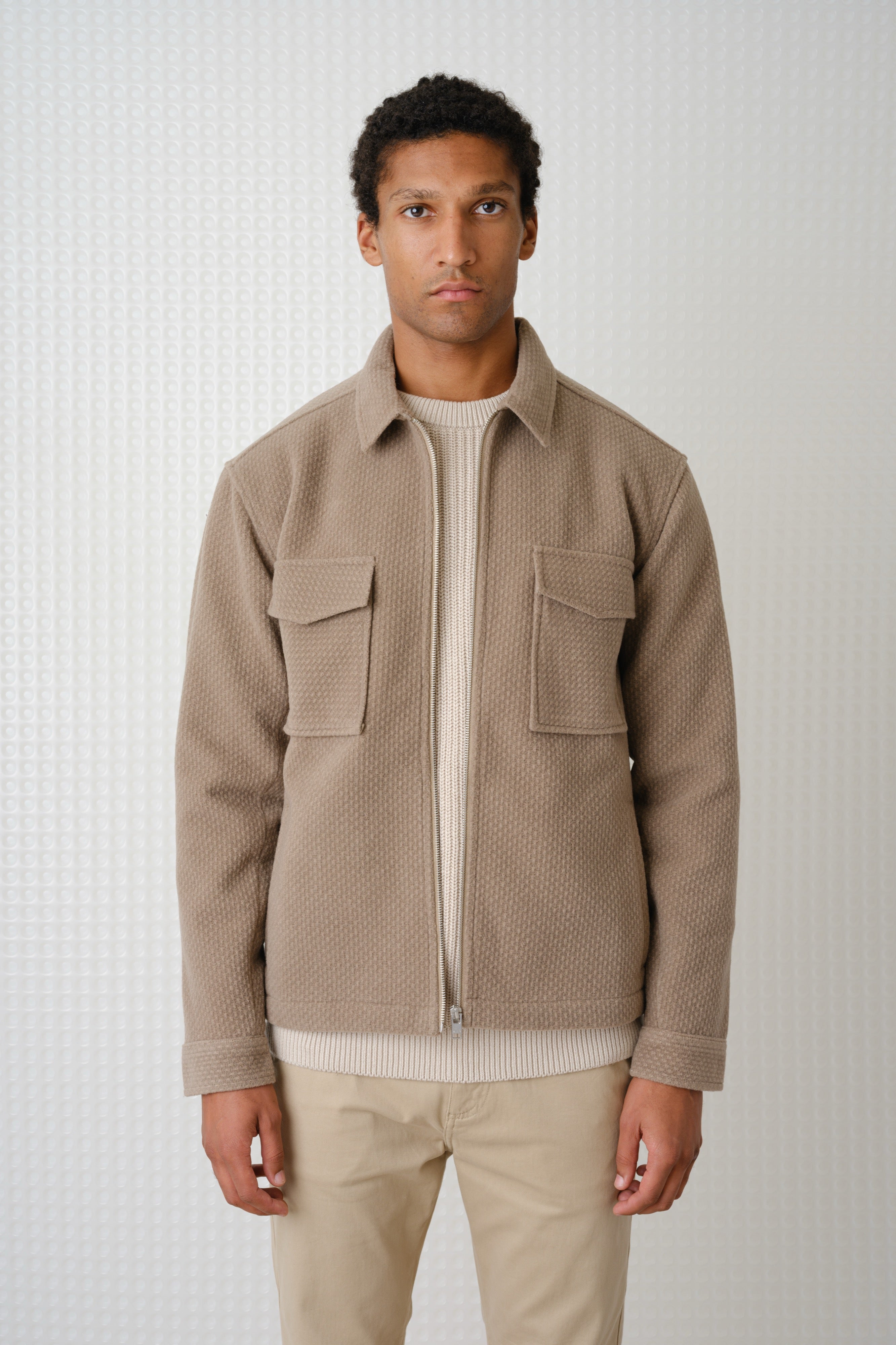 Man wearing a beige jacket with a white background